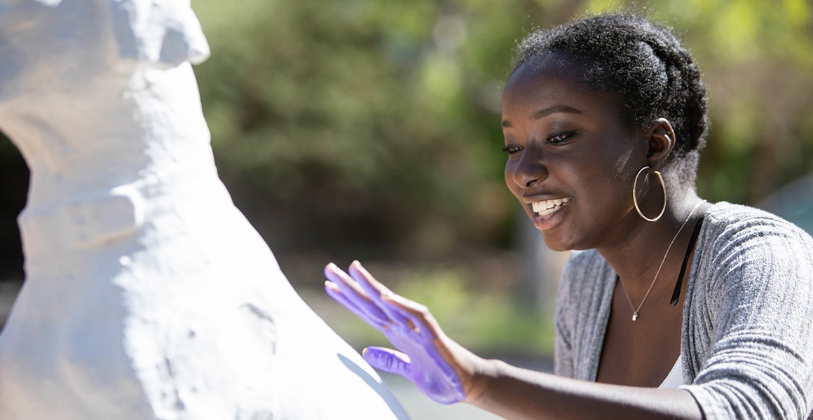 student leaving handprint on dog statue