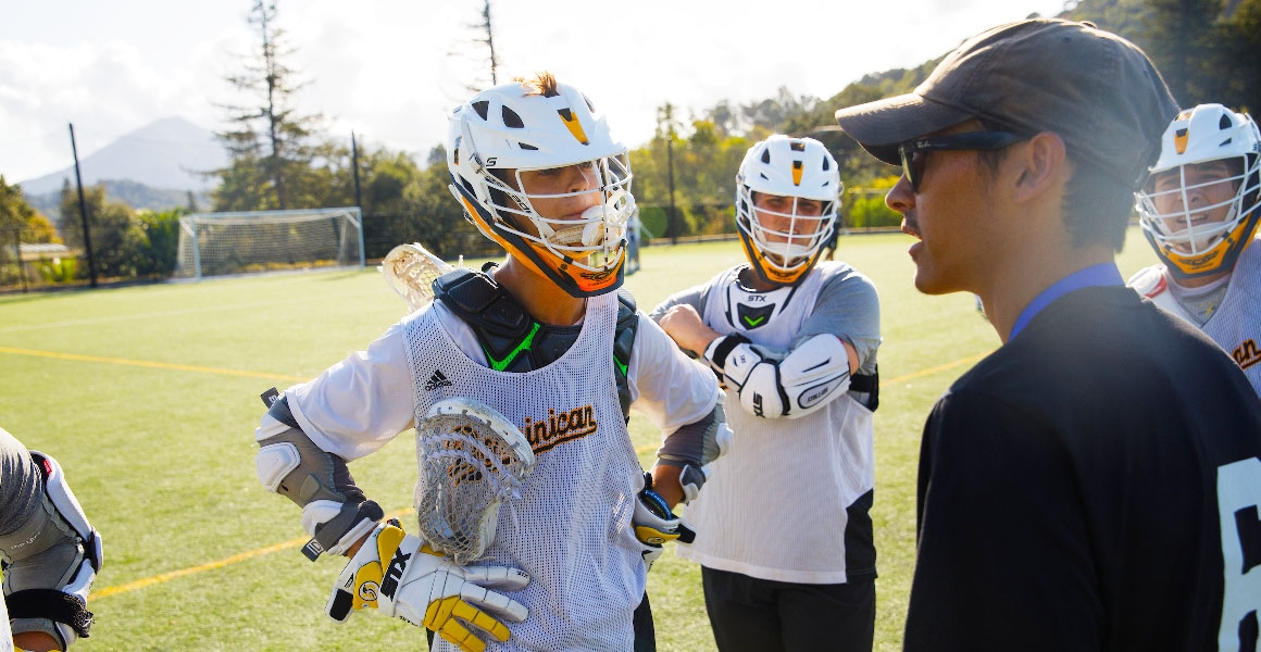 lacrosse players with coach