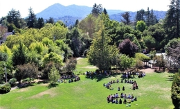 File photo from high up of groups of incoming students in circles on the Meadowlands Hall lawn with Mt. Tam off in the distance
