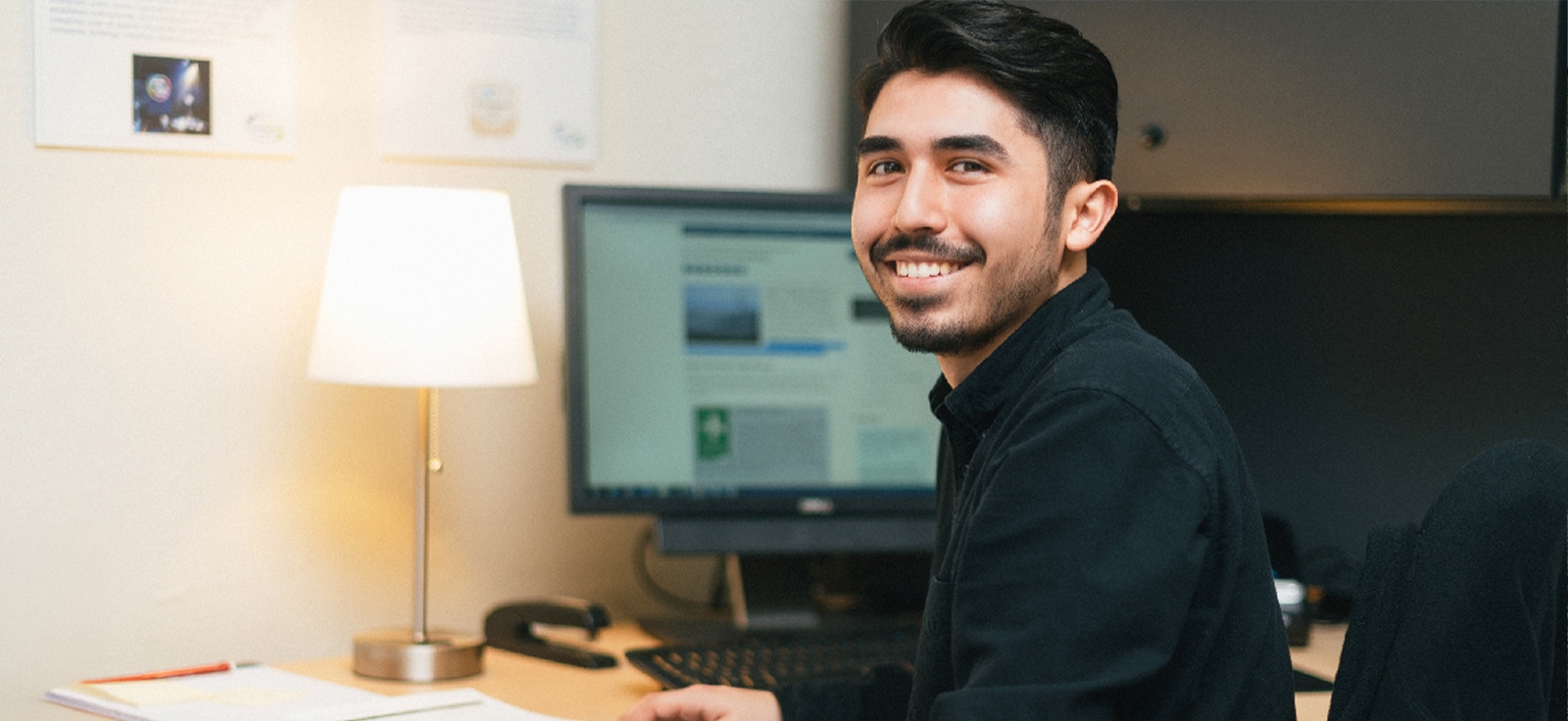 Student at computer smiling