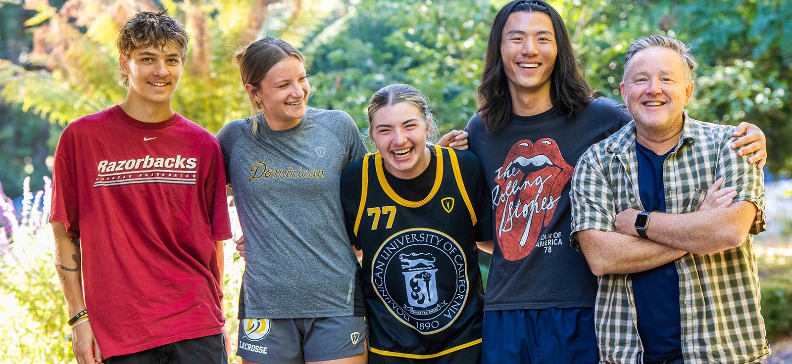 Students and professor outdoors, laughing. 