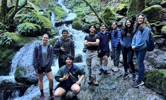 A group of Dominican students posing together during a nature hike.