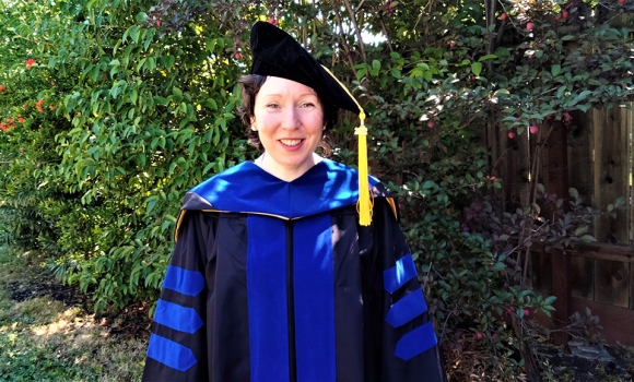 Photo of Dr. Dawn Fiacco posing in blue cap and gown at doctorate ceremony for Art Therapy program at Dominican commencement 2022